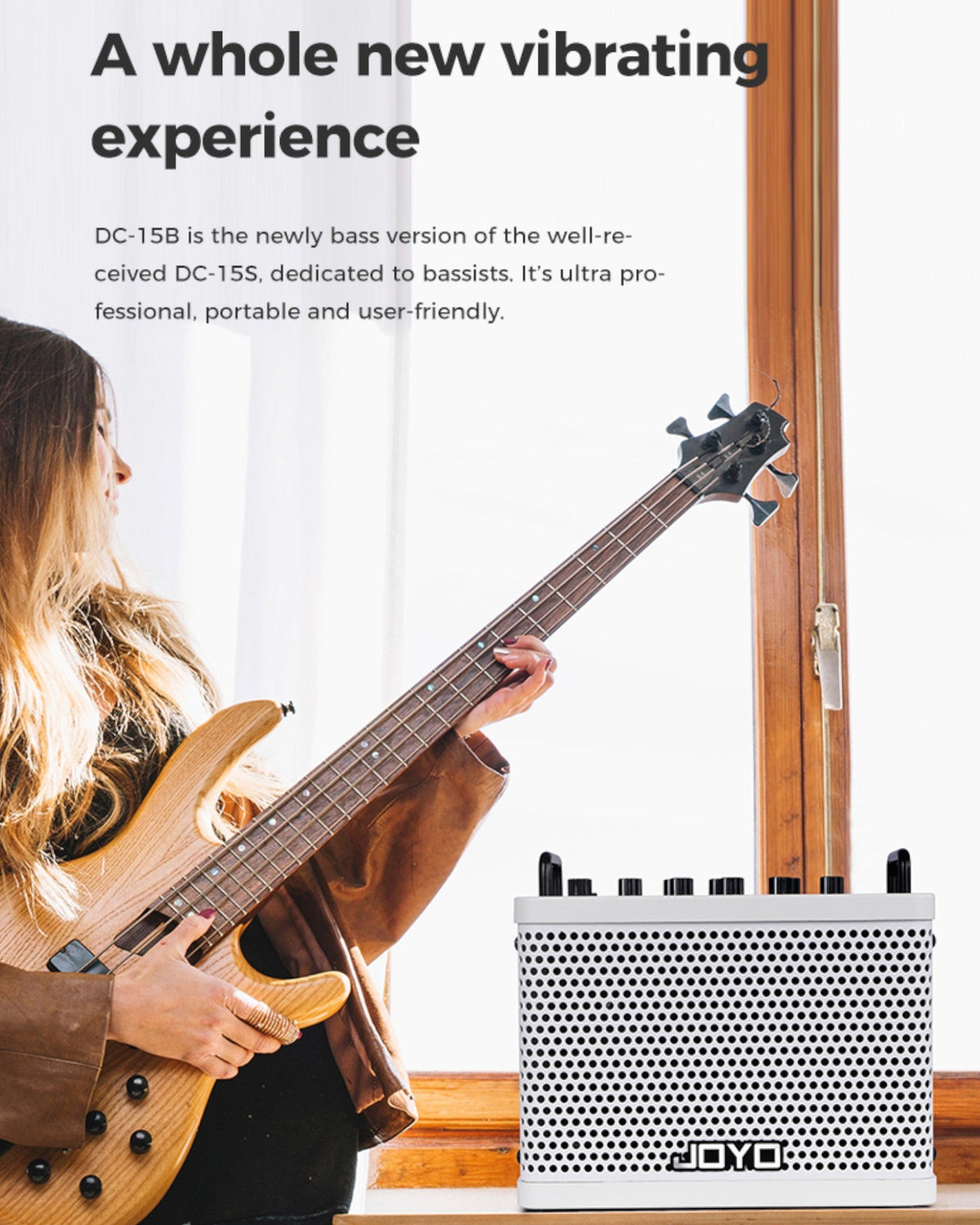 Haze Guitar Australia Joyo DC15B portable bass amp with a musician playing a bass guitar by a window