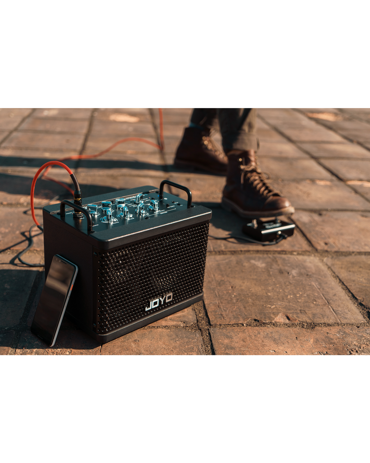Haze Guitar Australia Joyo DC15S portable 15W guitar amplifier with footswitch and smartphone on outdoor pavement