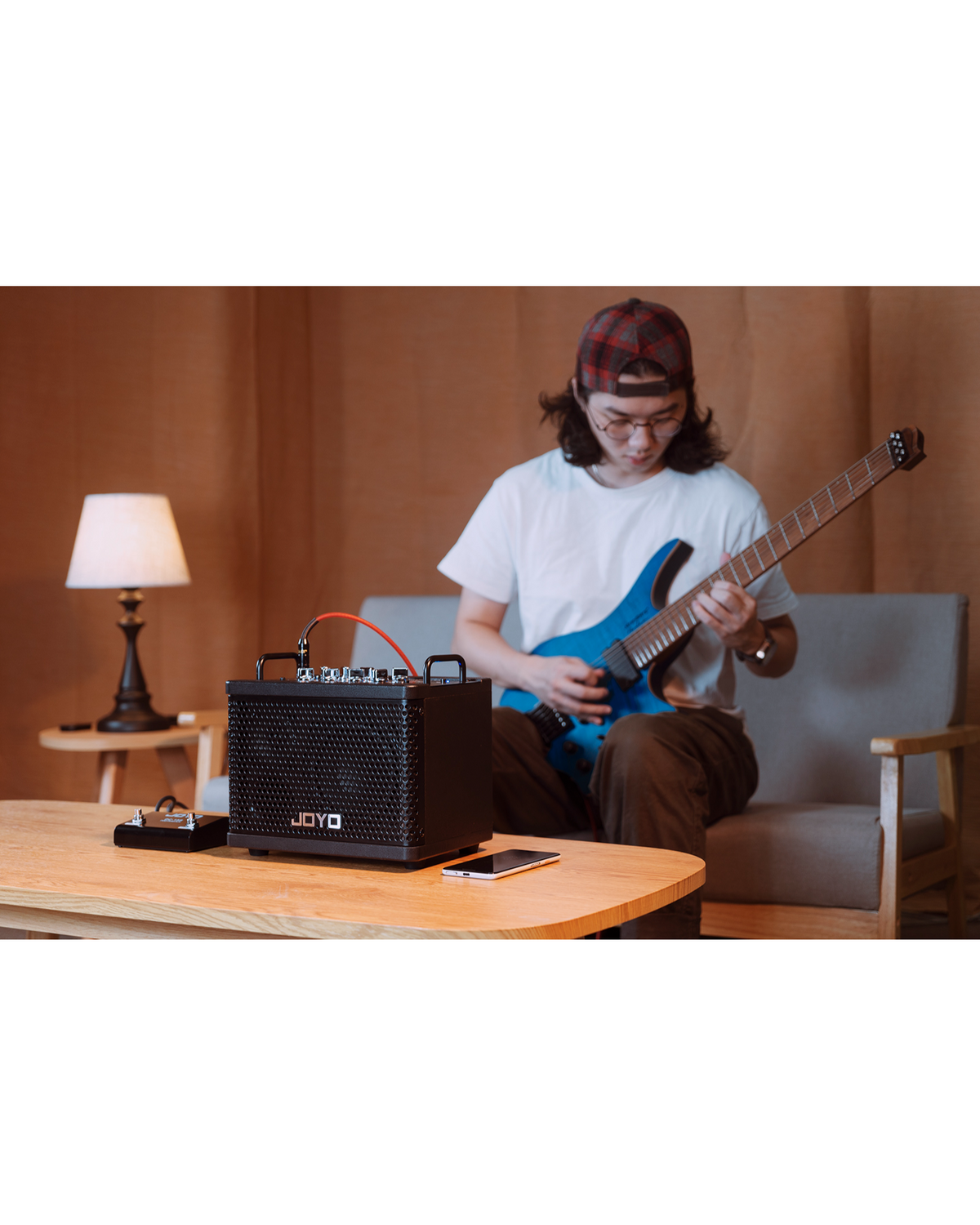 Haze Guitar Australia Joyo DC15S portable guitar amplifier with footswitch, played by a guitarist in a home setting.